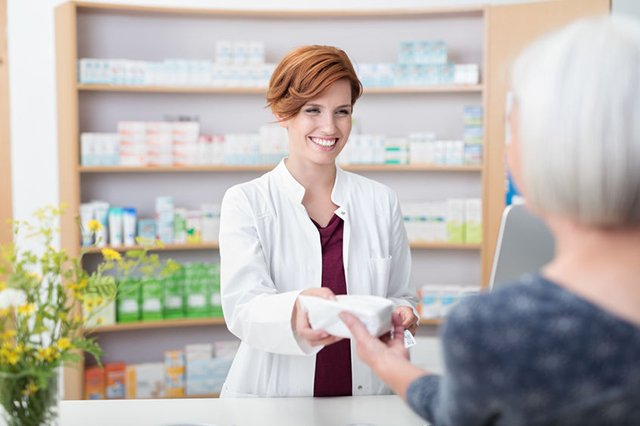 Image of pharmacist handing over prescription to a patient