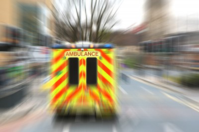 Photo of ambulance. Rear shot with blurred scenery depicting fast forward movement.