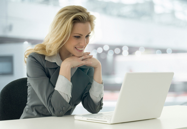 Image of lady looking at laptop screen and smiling