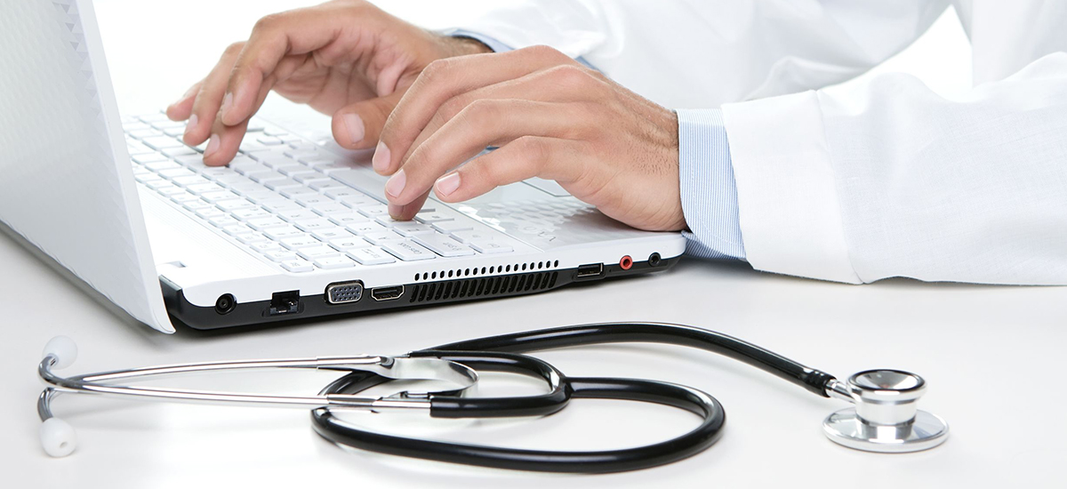 Cropped slide image showing a laptop, a clinician's hands typing and a stethescope on a table
