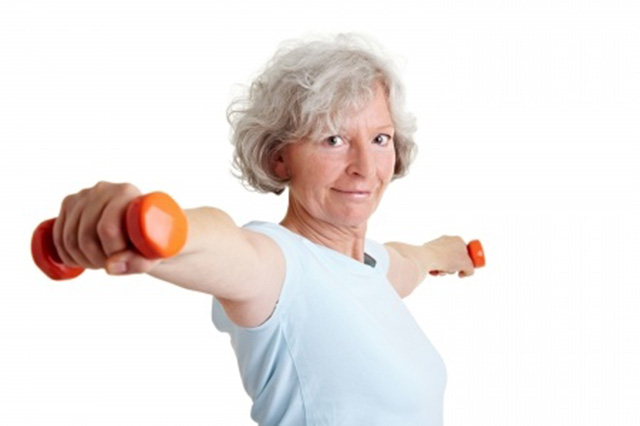 Image of older lady hodling small weights with extended arms