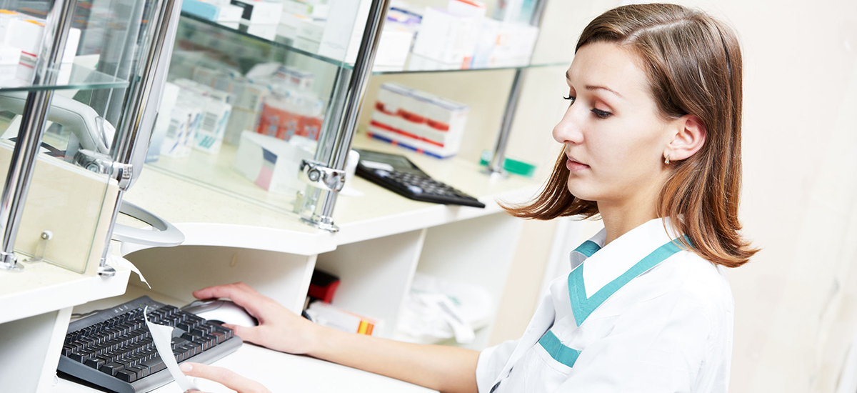 Slide Image of pharmacy assistant typing on a computer keyboard
